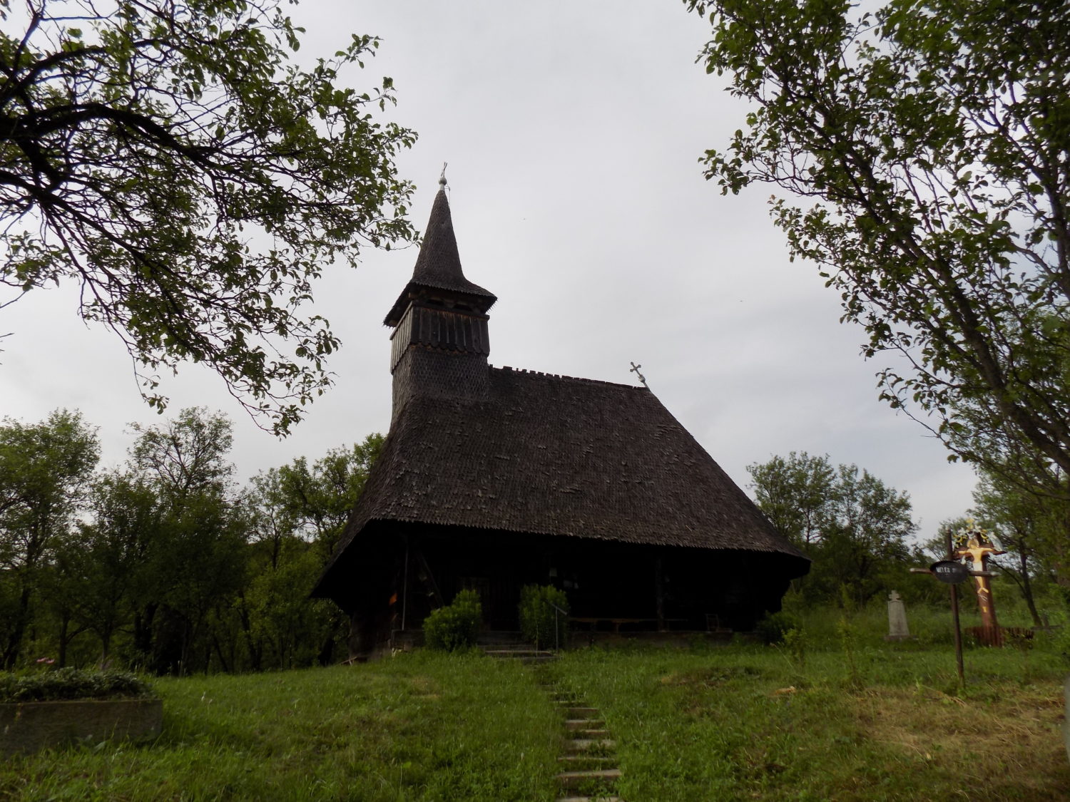 Biserica Sfanta Treime din Agarbiciu, o biserica traditionala din lemn cu acoperis inalt, situata intr-o zona verde si linistita, inconjurata de copaci