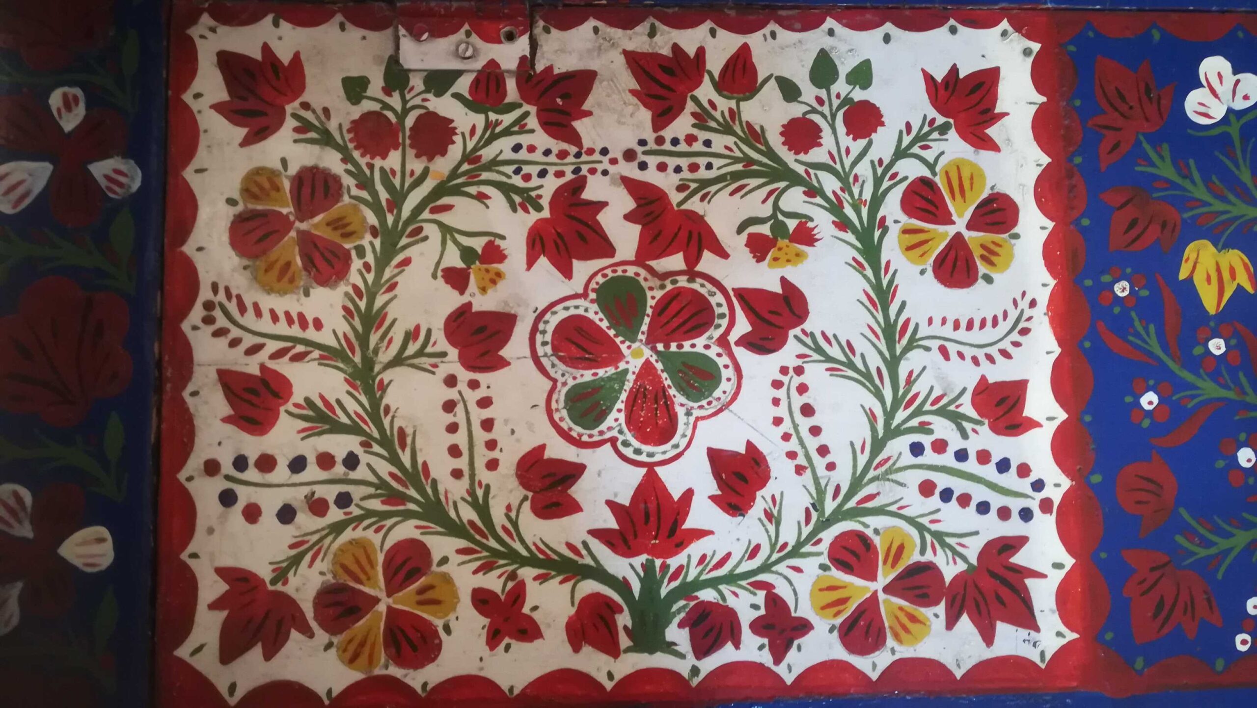 Imaginea reprezinta un model floral traditional din colectia etnografica Kallós Zoltán, cu motive vegetale rosu-verde, simbolizand natura si traditia artistica rurala